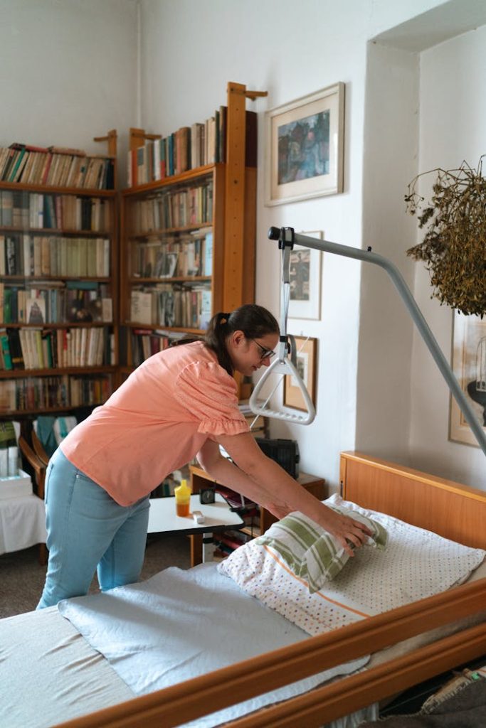 A caregiver adjusts bedding in a cozy home library setting in Prague.